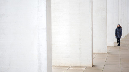 young woman standing outside at the end of wall