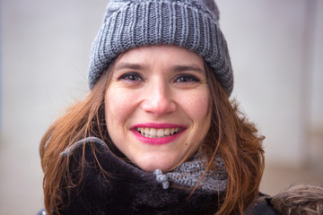 portrait of smiling young woman standing outside in the cold