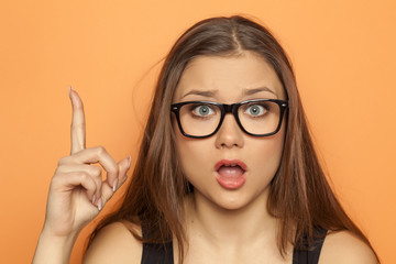 young girl has an idea and pointing a finger upwards