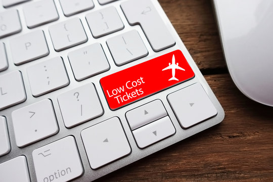 Low Fare Or Cheap Flights Concept Suggested By White Computer Keyboard With Low Cost Tickets Text On Red Enter Key
