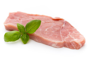 Fresh pork fillet with basil on a white background.