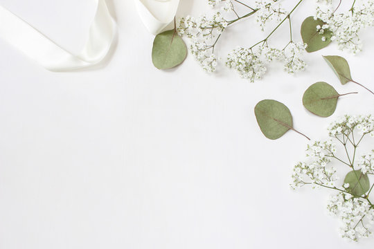 Styled stock photo. Feminine wedding desktop mockup with baby's breath  Gypsophila flowers, dry green eucalyptus leaves, satin ribbon and white  background. Empty space. Top view. Picture for blog. Photos | Adobe Stock