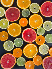 Fototapeta na wymiar citrus fruit slices on dark surface
