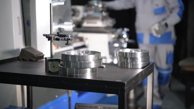 Metal Elements Made Using Metal Lathe Closeup Video. Working Lathe Operator in the Background