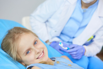 Little girl sitting in the dentists office