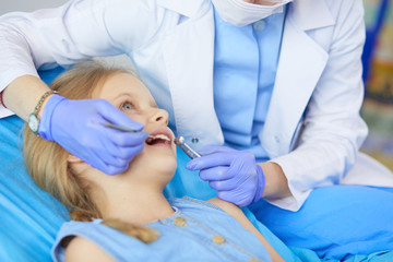 Naklejka premium Little girl sitting in the dentists office