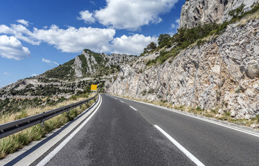 Country road through the rocky mountains and forest.