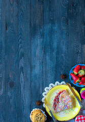 Fresh homemade crepes served on a plate with strawberries and blueberries, on a dark wooden background,