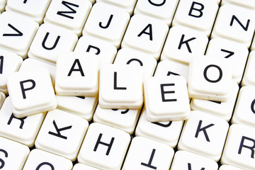 Paleo text word crossword title caption label cover background. Alphabet letter toy blocks. White alphabetical letters.