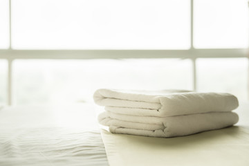 Close-up white towel on the bed, Spa towel folded on bed in hotel with window light