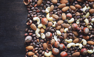 Different nuts on a wooden table. Cedar, cashew, hazelnut, walnu