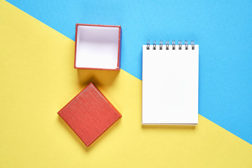 Red gift box,and empty notebook on pastel background, Free space on the notebook for placing text.