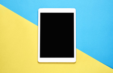 Top view, Modern workplace with tablet placed on a pastel yellow background. Copy space suitable...