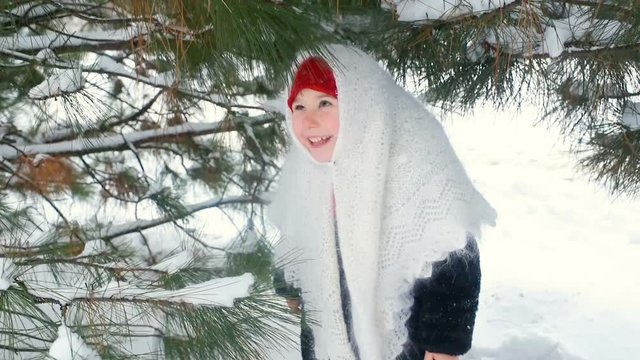 portrait of a child girl in a headscarf in the Urs style on the background of snow and forest. Russia, frost, fairy tale, carnival