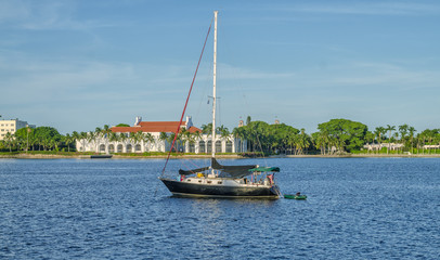 Yacht in the middle of the river with lowered sails