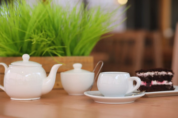 Kettle with a drink and dessert in a street cafe. Tea in the ket