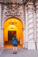 Woman Framed by Large Columns and Arch in Orange Light