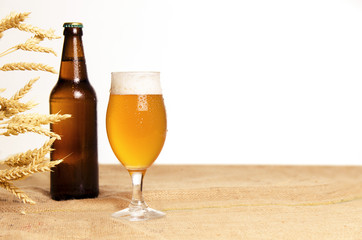 Fresh wheat beer copy space, wheat, beer bottle and glass on jute bag