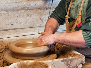 Potter makes a clay plate.