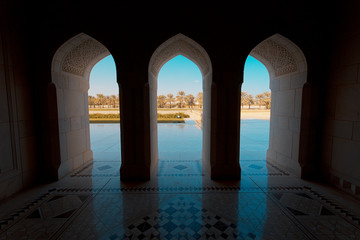 Exotic palm oasis view from inside a building with Islamic architecture 