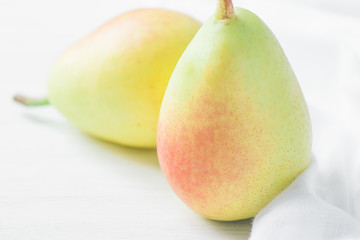 Couple of Ripe Organic Pears in Pastel Green Yellow Red Colors on White Wood and Linen Fabric. Elegant Minimalist Japanese Style. Creative Image for Social Media Blog Product Branding. Healthy Food