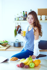 Young woman standing near desk in the kitchen. Young woman .