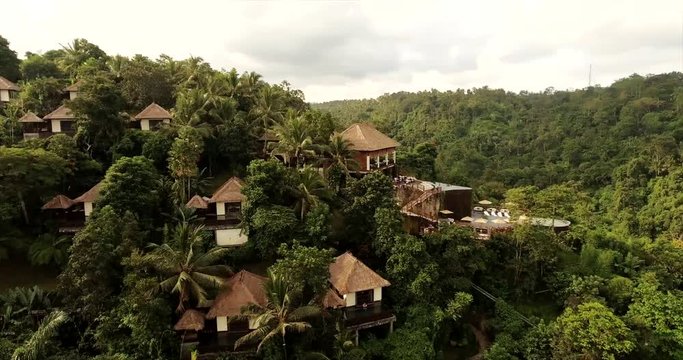 Aerial view of luxury resort in forest surrounded by trees. Hotel with villas in forest.