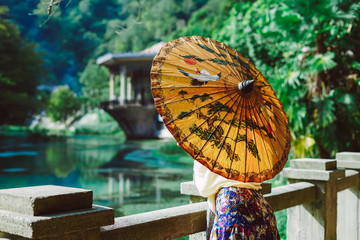 woman holds an umbrella in her hand and looks at the lake © mnelen.com