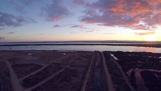 Drone footage of remote industrial area near power station and high-voltage towers at sunrise. Taken at Outer Harbor, Port Adelaide, South Australia.