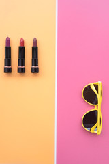 close up of color lipsticks and sunglasses for background