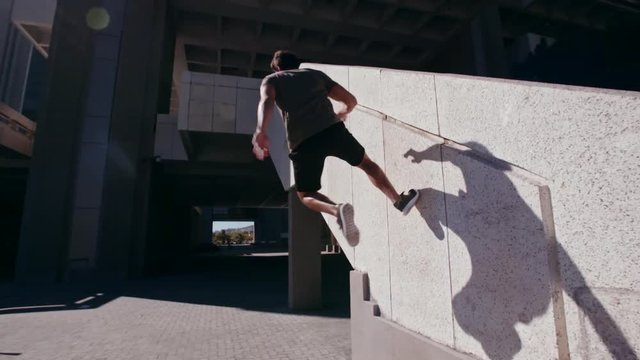Free runners performing parkour in urban space. People doing parkour tricking and freerunning in the city. 