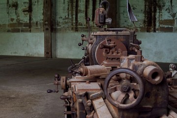 Grain Image: Close up of old machine factory made of steel and used in the past. Broken and rustic machine left over in abandon factory. Image of aged equipment with rust and gear part.