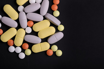  multicolored tablets of oval and round shape on a black background