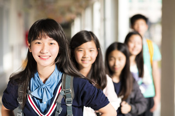 Group Of Teenage Students standing before classroom