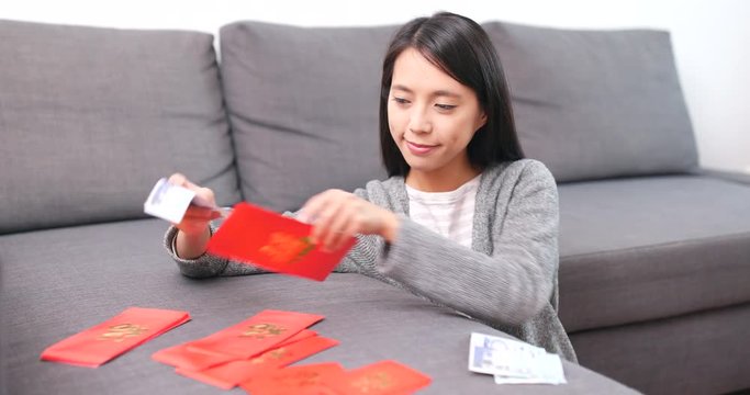 Woman putting money inside red packet for lunar new year