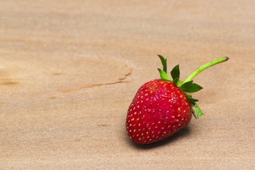A tasty strawberry on wooden background