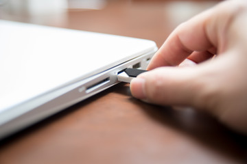 Plugging in and unplugging the USB flash memory to the laptop pc computer.