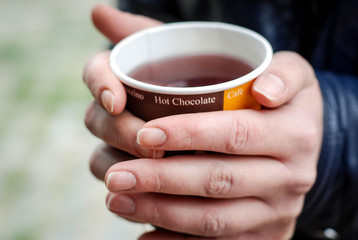 Hot Drink Tea in Paper Cup in Hands Close up with Blurred Background