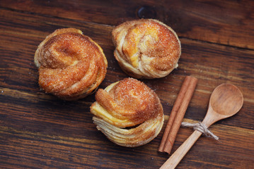 Bakery Homemade Buns fresh Pastriest on a Rustic wooden background. Top view. wooden Spoon and cinnamon Stick.