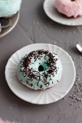 Donuts with chocolate and coconut on a gray background (close-up)