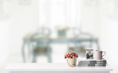 Mock up: Workspace desk with books,coffee mug and glass jar with coins,white desk with copy space for products display