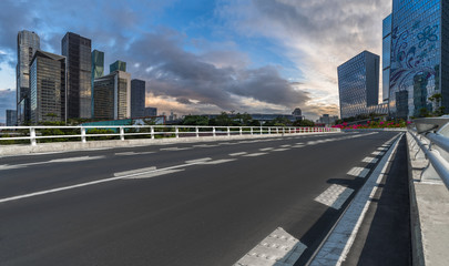 Obraz premium road through the bridge with city skyline background at twilight