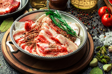 Raw meat on the kitchen table on a metallic background in a composition with cooking accessories