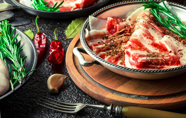 Raw meat on the kitchen table on a metallic background in a composition with cooking accessories