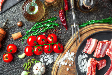 Raw meat on the kitchen table on a metallic background in a composition with cooking accessories