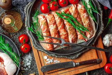 Raw meat on the kitchen table on a metallic background in a composition with cooking accessories