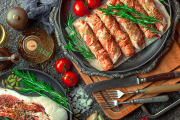 Raw meat on the kitchen table on a metallic background in a composition with cooking accessories