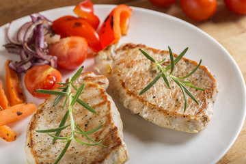 Fried pieces of pork chop with roasted vegetables