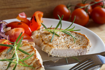 Fried pieces of pork chop with roasted vegetables on a plate