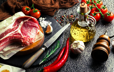 Raw meat on the kitchen table on a metallic background in a composition with cooking accessories